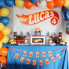 a blue table topped with cake and balloons