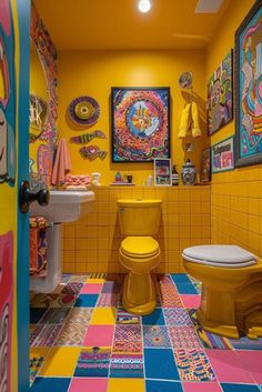 a brightly colored bathroom with yellow walls and floor tiles on the wall, colorful artwork above the toilet