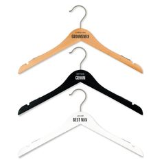 three wooden clothes hangers with black, white and brown labels on each one side