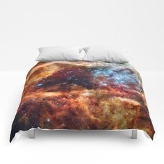 a bed covered in a blanket with an image of the stars and planets on it