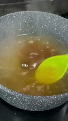 there is a spoon in a bowl with liquid on the stove top next to it