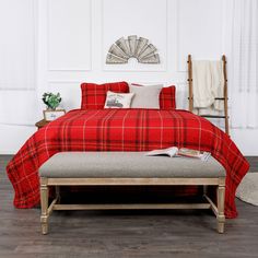 a bed with red plaid sheets and pillows