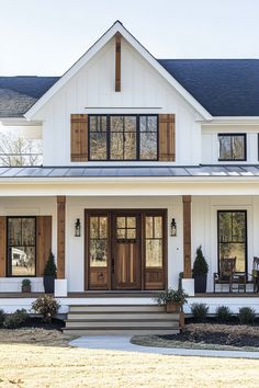 a large white house with wooden doors and windows on the front porch is pictured in this image