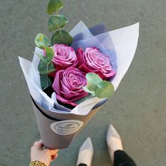 a person holding a bouquet of pink roses