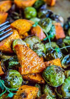 a close up of a plate of food with brussels sprouts and sweet potatoes