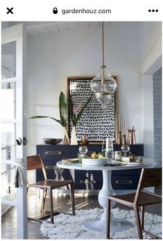 a dining room table with chairs and a rug on the floor in front of it