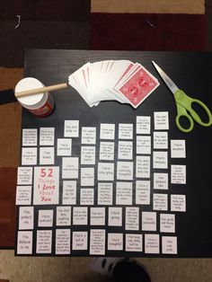 the table is covered with cards and scissors for playing card games on black paper, which are numbered in red