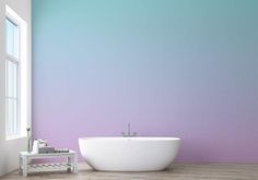 a white bath tub sitting on top of a wooden floor