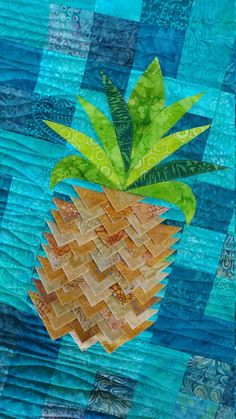 a quilted pineapple with green leaves on it