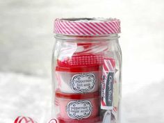 a jar filled with candy canes sitting on top of a white table next to a peppermint