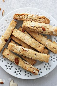 almond biscuits on a white plate next to sliced almonds and toasted almonds