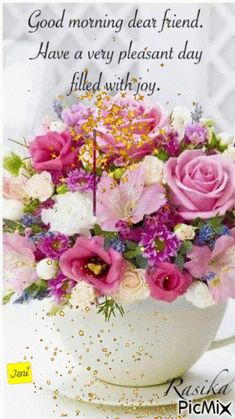 a cup filled with pink and white flowers on top of a table