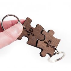 a person holding two pieces of a puzzle keychain with the words set not complete on it