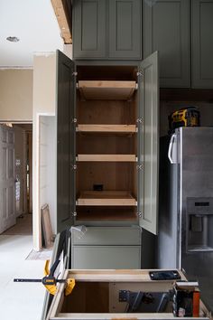 an open cabinet in the middle of a kitchen