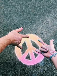 two people reaching out to each other with peace painted on the ground in front of them