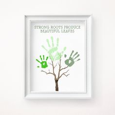 a white frame with a tree and handprints on the bottom that says strong roots produce beautiful leaves