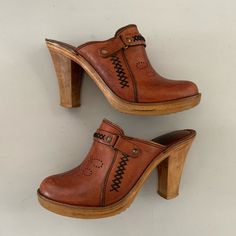 "Gorgeous vintage clogs. Brown leather upper. Wooden sole. Grommet and stitching details. Made by Highlights. Size: 6 Insole: 9\" Heel height: 3 3/4\" Width at ball of foot: 3\" PLEASE READ Condition: good Some signs of wear throughout. General scuffing to the leather, particularly on the toes. Soles have a couple minor dings, but overall in great shape. Leather has been freshly conditioned. Lots of life left in these bad boys. Feel free to ask questions prior to purchase, as all sales are final Retro Leather Platform Mules, Retro Style Platform Clogs With Round Toe, Retro Platform Clogs With Round Toe, High Heel Leather Clogs With Leather Footbed, Retro Brown Closed Toe Clogs, Western Leather Clogs With Round Toe, Retro Leather Clogs, Retro Leather Open Toe Mules, Vintage Brown Heels With Wooden Heel