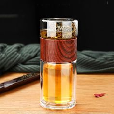 a glass cup filled with liquid sitting on top of a wooden table