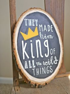 a wooden sign that says they made him king of all the weird things