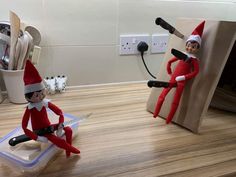 two elfs are sitting on the floor with scissors