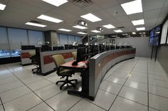 an empty office cubicle with desks and chairs