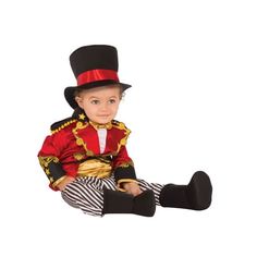 a little boy dressed in a red and black costume sitting on the ground with his legs crossed