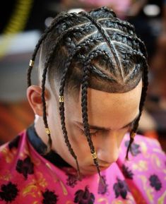 a young man with long box braids on his hair is looking down at the ground