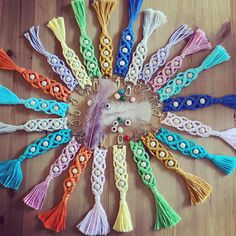 the colorful tassels are arranged in a circle on the wooden floor with beads