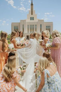 a group of women standing around each other in front of a church