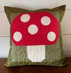 a red mushroom pillow sitting on top of a wooden table