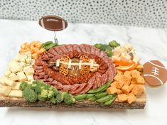 a football themed platter with meat, cheese and vegetables