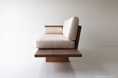 a chair that is sitting on top of a wooden block in front of a white wall