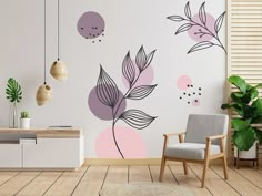 a room with a chair, plant and wall decals