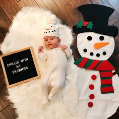 a baby is laying next to a snowman