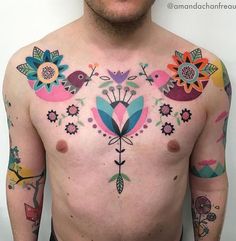 a man with tattoos on his chest has flowers and birds all over his chest area