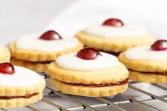 small cookies with cherries and cream filling on a cooling rack