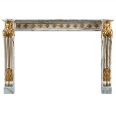 a white marble fireplace surround with gold leaf decorations on the top and sides, against a white background