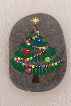 a painted rock with a christmas tree on it