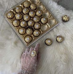 a woman's hand is shown next to a box of chocolates and several other candies