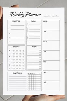 a person holding up a printable weekly planner