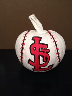 a painted baseball pumpkin sitting on top of a table