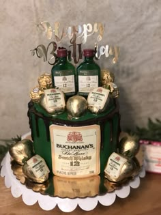 a birthday cake decorated with liquor bottles and gold decorations