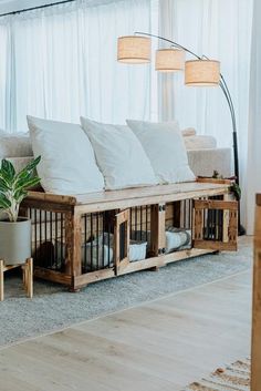 a couch made out of wooden crates with white pillows on top and some plants in the middle