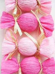 pink balls with gold ribbons and bows on them