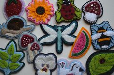 a bunch of embroidered patches with flowers and bugs on them, all in different colors