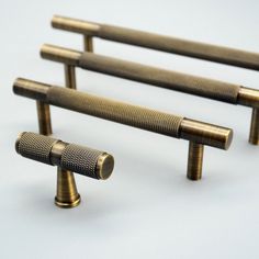 three brass - plated handles are shown on a white background