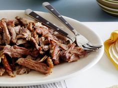 a white plate topped with meat and two forks