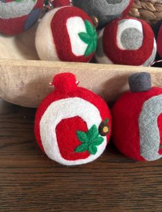 several red and white ornaments sitting on top of a wooden table