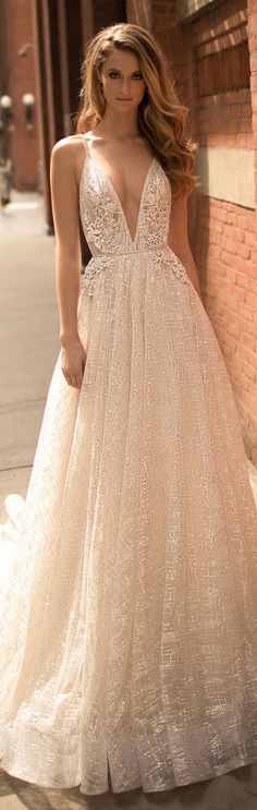 a woman standing next to a brick wall wearing a dress with sequins on it