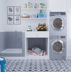 a washer and dryer in a bathroom with tile flooring on the walls